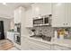 Modern kitchen features white cabinets, stainless steel appliances, herringbone backsplash, and quartz countertops at 3332 Delaware Dr, Denver, NC 28037