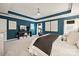 Spacious bedroom with blue accent walls, tray ceiling, peloton, and plush carpeting at 3332 Delaware Dr, Denver, NC 28037