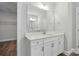 Bathroom with a white vanity, modern hardware, a large mirror and wood-look flooring at 4005 Grace Pointe Dr # 100, Wesley Chapel, NC 28079