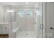 Large walk-in shower with bench seating and shower head with clear glass and white subway tile at 4005 Grace Pointe Dr # 100, Wesley Chapel, NC 28079