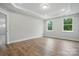 Spacious bedroom features beautiful wood floors, recessed lighting, and natural light from two windows at 4005 Grace Pointe Dr # 100, Wesley Chapel, NC 28079