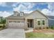 Two-story home with a two car garage and landscaping at 4005 Grace Pointe Dr # 100, Wesley Chapel, NC 28079