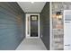 Close-up of the elegant front door, complemented by stylish stonework and modern lighting at 4005 Grace Pointe Dr # 100, Wesley Chapel, NC 28079