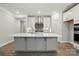 Bright kitchen featuring large island, white cabinets, stainless steel appliances, and stylish backsplash at 4005 Grace Pointe Dr # 100, Wesley Chapel, NC 28079