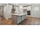 Modern kitchen boasts a central island, stainless steel appliances, and white cabinetry at 4005 Grace Pointe Dr # 100, Wesley Chapel, NC 28079