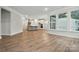 Open-concept living room leading to the kitchen features hardwood floors and multiple windows at 4005 Grace Pointe Dr # 100, Wesley Chapel, NC 28079