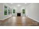 Bright living room featuring a fireplace, wood floors, and natural light from three windows at 4005 Grace Pointe Dr # 100, Wesley Chapel, NC 28079