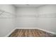A neutral walk-in closet featuring built-in shelving and laminate flooring at 4005 Grace Pointe Dr # 100, Wesley Chapel, NC 28079