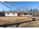 Ranch style home with light beige siding, front door, and small landscaping at 41943 Gurley Rd, New London, NC 28127