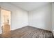 Empty spare bedroom with wood-look floors and a view into the kitchen at 4649 Maple Crest Pl, Harrisburg, NC 28075