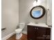 Clean bathroom with dark vanity and round mirror at 5124 Craftsman Ridge Dr, Matthews, NC 28104