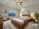 Virtually staged main bedroom with a large bed and plenty of natural light at 5124 Craftsman Ridge Dr, Matthews, NC 28104