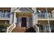 Main entrance to a condo building with stairs and a brown door at 6127 Meadow Rose Ln, Charlotte, NC 28215