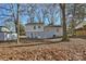 House and backyard with mature trees and leaf covered ground at 6706 Queensberry Dr, Charlotte, NC 28226