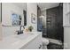 Modern bathroom with white vanity, marble countertops, and a dark hexagon tile shower at 6706 Queensberry Dr, Charlotte, NC 28226