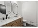 Elegant bathroom with double vanity, chevron cabinets, and oval mirrors at 6706 Queensberry Dr, Charlotte, NC 28226