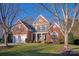 Brick two-story house with a three-car garage and manicured landscaping at 819 Lillieshall Rd, Waxhaw, NC 28173