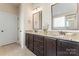 Double vanity bathroom with granite countertops and dark wood cabinets at 9124 Longvale Ln, Charlotte, NC 28214