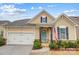 Tan two-story house with a white garage door and landscaping at 1009 Chapman St, Indian Trail, NC 28079