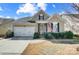 Tan house with white garage door, landscaping, and American flag at 1009 Chapman St, Indian Trail, NC 28079