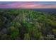 Aerial perspective of a wooded home at dusk at 10200 Amsterdam Dr, Mount Pleasant, NC 28124