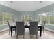 Bright dining room features large windows and stylish gray chairs around a dark wood table at 10200 Amsterdam Dr, Mount Pleasant, NC 28124