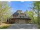 Exterior view of a home with a unique circular design, elevated deck, and a spacious lower garage at 10200 Amsterdam Dr, Mount Pleasant, NC 28124
