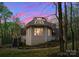 A side view of the home showcases unique architecture with an outdoor deck and natural surroundings at 10200 Amsterdam Dr, Mount Pleasant, NC 28124