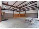 Inside the large garage, featuring a concrete floor, orange cabinets, and a picnic table at 10200 Amsterdam Dr, Mount Pleasant, NC 28124