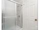 Bathroom with updated shower featuring glass door and marble-style tile at 10240 Rose Meadow Ln # D, Charlotte, NC 28277