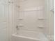 Bathroom with shower/tub, shelving, and white tile at 10240 Rose Meadow Ln # D, Charlotte, NC 28277