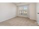 Well-lit bedroom featuring carpet, large window, and neutral wall colors at 10240 Rose Meadow Ln # D, Charlotte, NC 28277