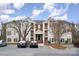 Exterior view of a three-story building with brick and beige siding and manicured landscaping at 10240 Rose Meadow Ln # D, Charlotte, NC 28277