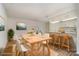 Bright dining area featuring hardwood floors, wooden table, and adjacent breakfast bar with marble countertops at 10240 Rose Meadow Ln # D, Charlotte, NC 28277