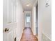 Hallway with wood flooring, leading to rooms with carpet at 10240 Rose Meadow Ln # D, Charlotte, NC 28277