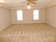 Spacious bedroom featuring neutral tones, carpet, ceiling fan, and natural light from the two windows at 110 Robin Rd, Lincolnton, NC 28092