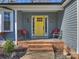 Inviting front porch with yellow door and brick steps at 1147 Bloom Wood Ln, Matthews, NC 28105