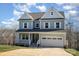 Two-story light blue house with white shutters, double garage, and landscaped yard at 12060 Mariners Cove Ct, Lancaster, SC 29720