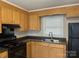 Cozy kitchen featuring wood cabinets and black appliances at 1219 Stevens Cir, Gastonia, NC 28054