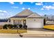 Tan house with a white garage door and landscaping at 124 Zolder Ln # 15, Mooresville, NC 28117