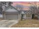 Brick ranch home with gray garage door and landscaped lawn at 14023 Kedleston Rd, Huntersville, NC 28078