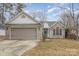 Brick ranch home with gray garage door and landscaped lawn at 14023 Kedleston Rd, Huntersville, NC 28078