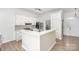 White kitchen with L-shaped island and mosaic backsplash at 14023 Kedleston Rd, Huntersville, NC 28078