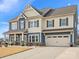 Two-story house, gray roof, blue and beige siding, front porch, attached garage at 1503 Brooksland Pl, Waxhaw, NC 28173