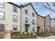 Three-story townhouses with brick and siding exteriors, showcasing landscaping and walkways at 1554 Kee Ct, Charlotte, NC 28203