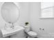 Modern powder room with a sleek vessel sink, round mirror, and neutral decor at 3113 Beacon Heights Rd, Indian Land, SC 29707