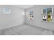 Bright bedroom featuring three windows, neutral walls, and plush gray carpeting at 3113 Beacon Heights Rd, Indian Land, SC 29707