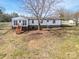 Back exterior view of this beautiful home, featuring a spacious yard and deck with stairs at 3416 Polkville Rd, Shelby, NC 28150