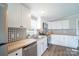 Bright kitchen featuring stainless appliances, white cabinetry, and black and white backsplash at 3416 Polkville Rd, Shelby, NC 28150