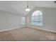 Spacious bedroom with vaulted ceiling, carpet flooring, and multiple windows at 4829 Boomerang Way, Charlotte, NC 28269